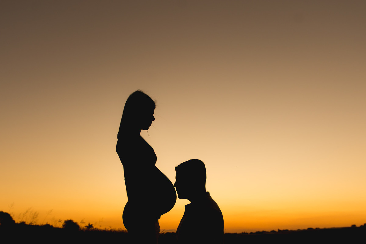 casal gestante com o por do sol em Holambra
