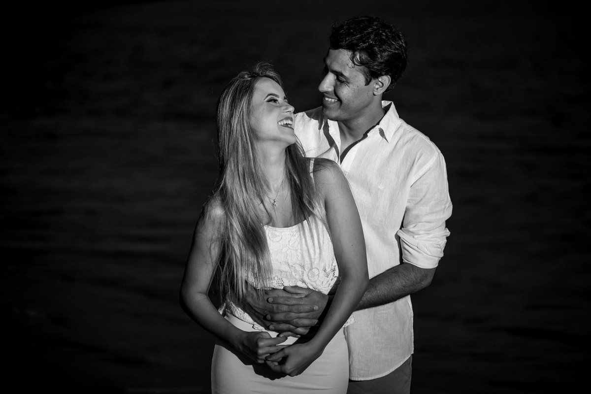 casal se olhando com mar de fundo