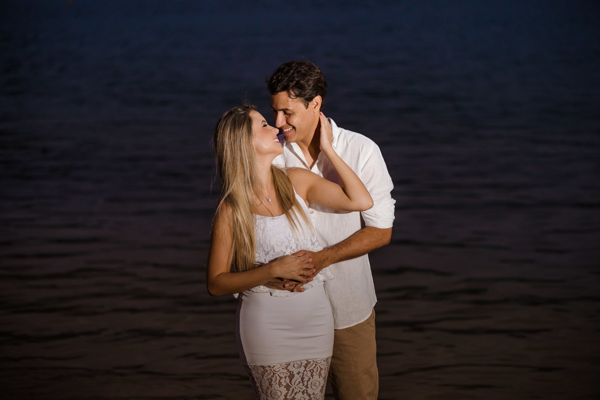 casal se olhando com o mar de fundo
