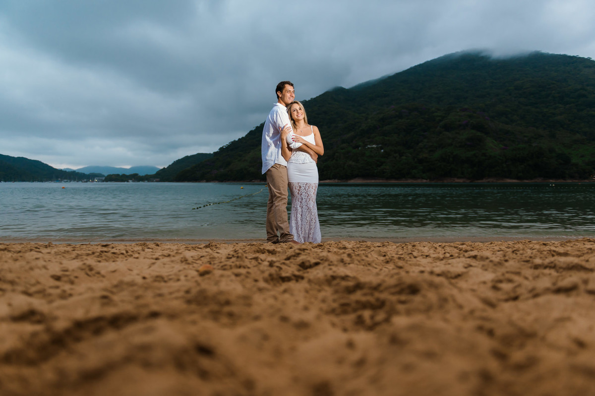 casal abraçados na beira da praia