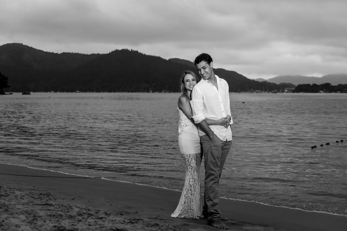 casal abraçados com o mar de fundo