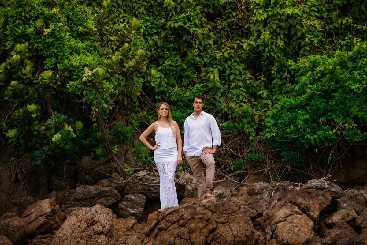 casal em rocha com o mar