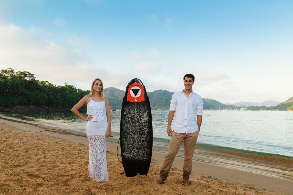 casal juntos com prancha de surf na praia