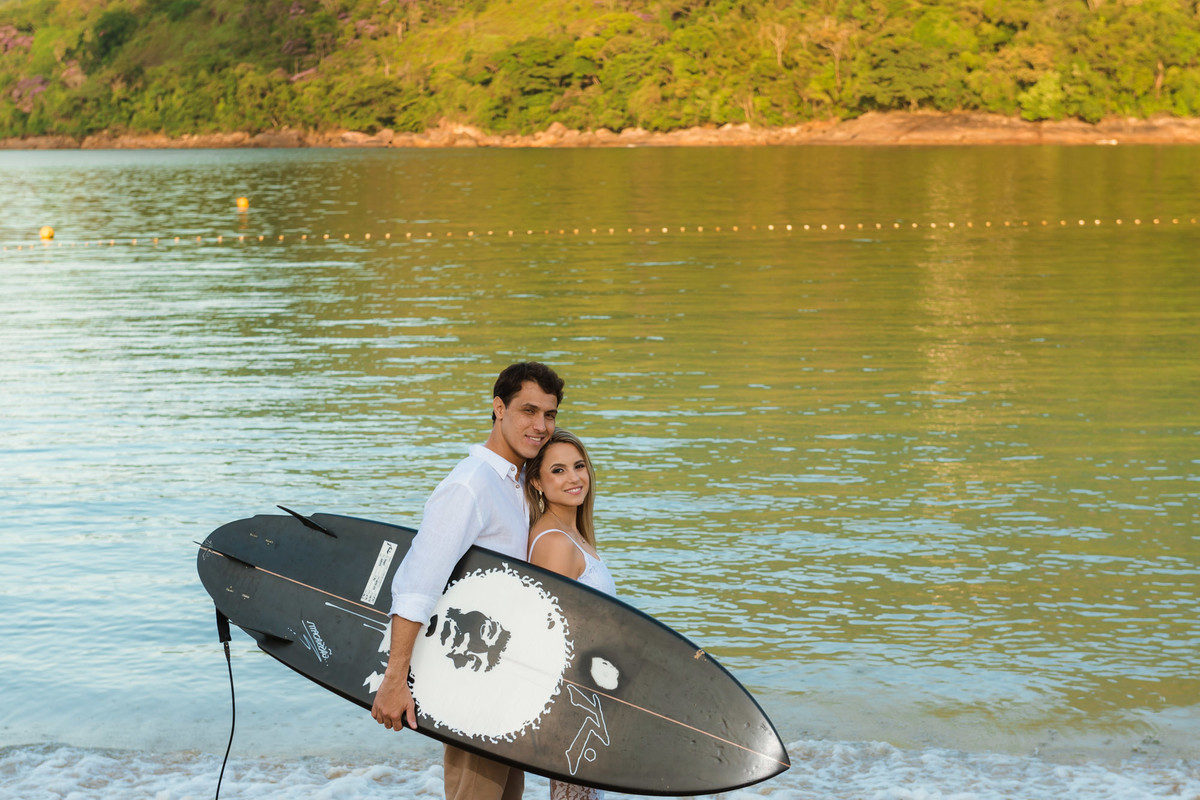 casal juntos com prancha de surf na praia