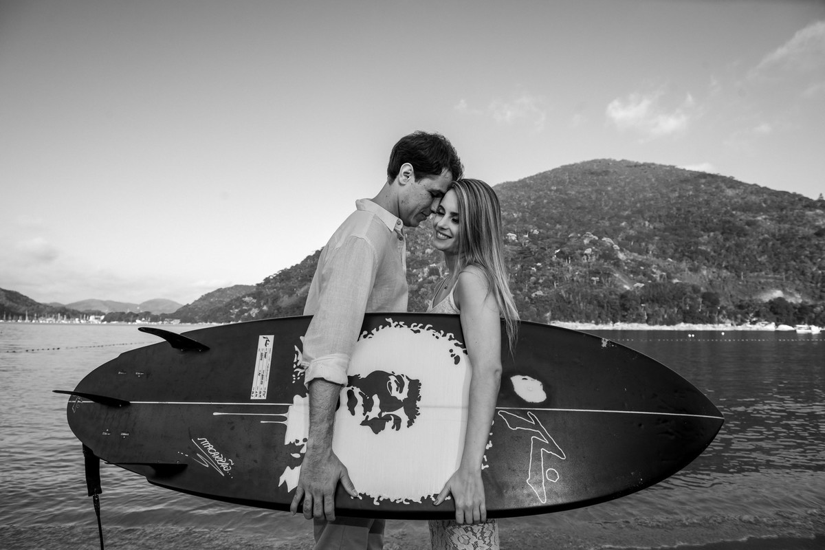 casal juntos com prancha de surf na praia