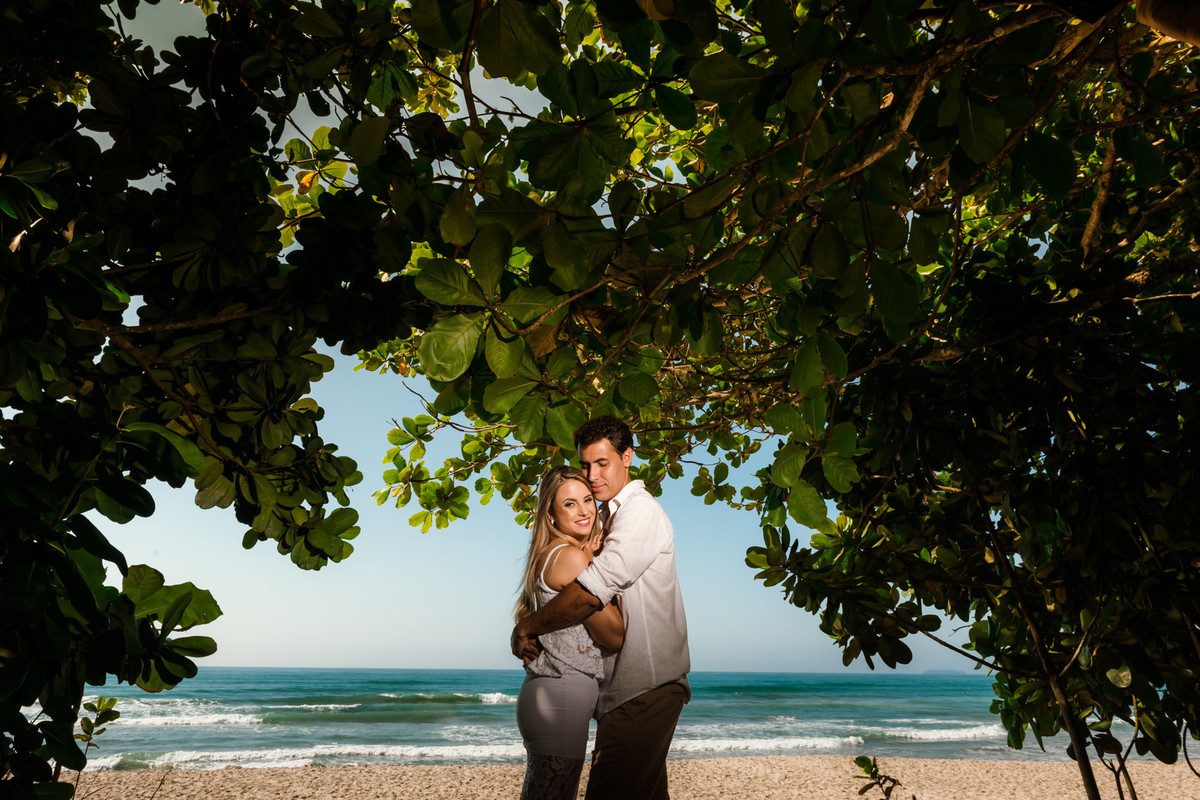 casal abraçados na praia com mar de fundo