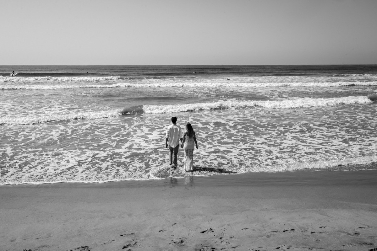 casal caminhando em direção ao mar