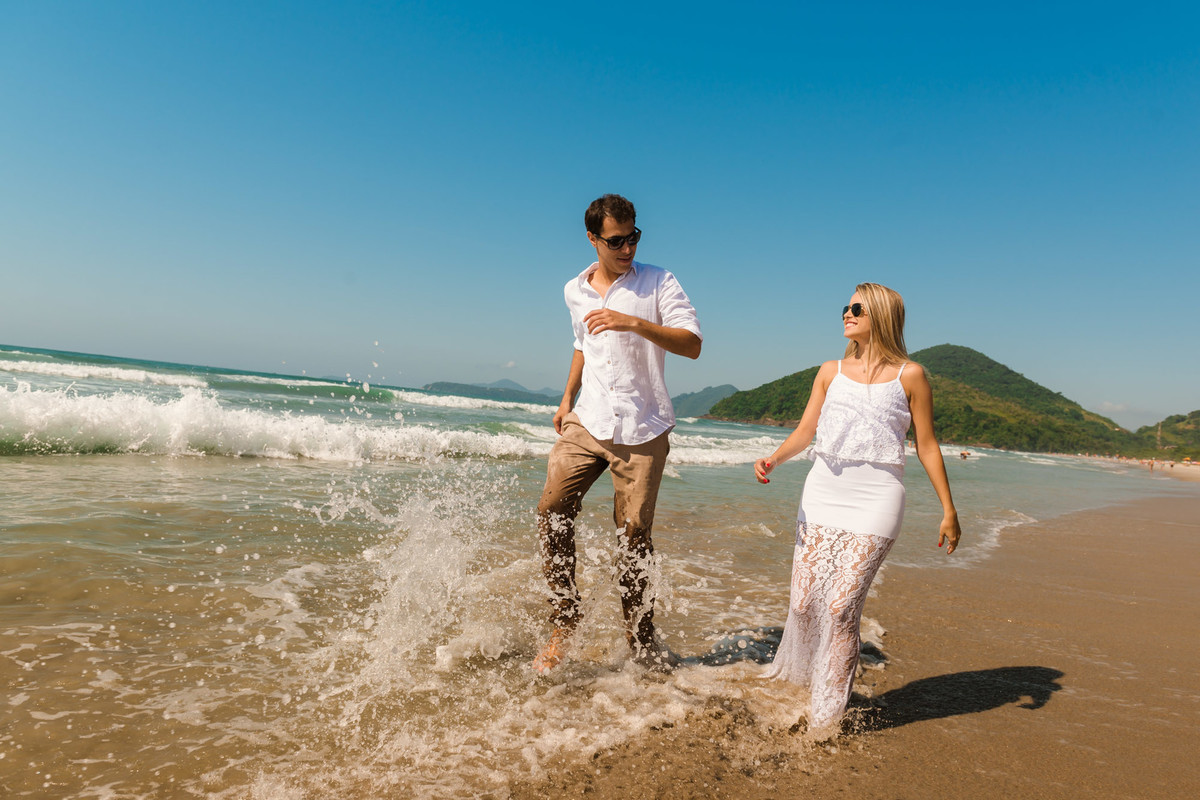 casal caminhando em direção ao mar