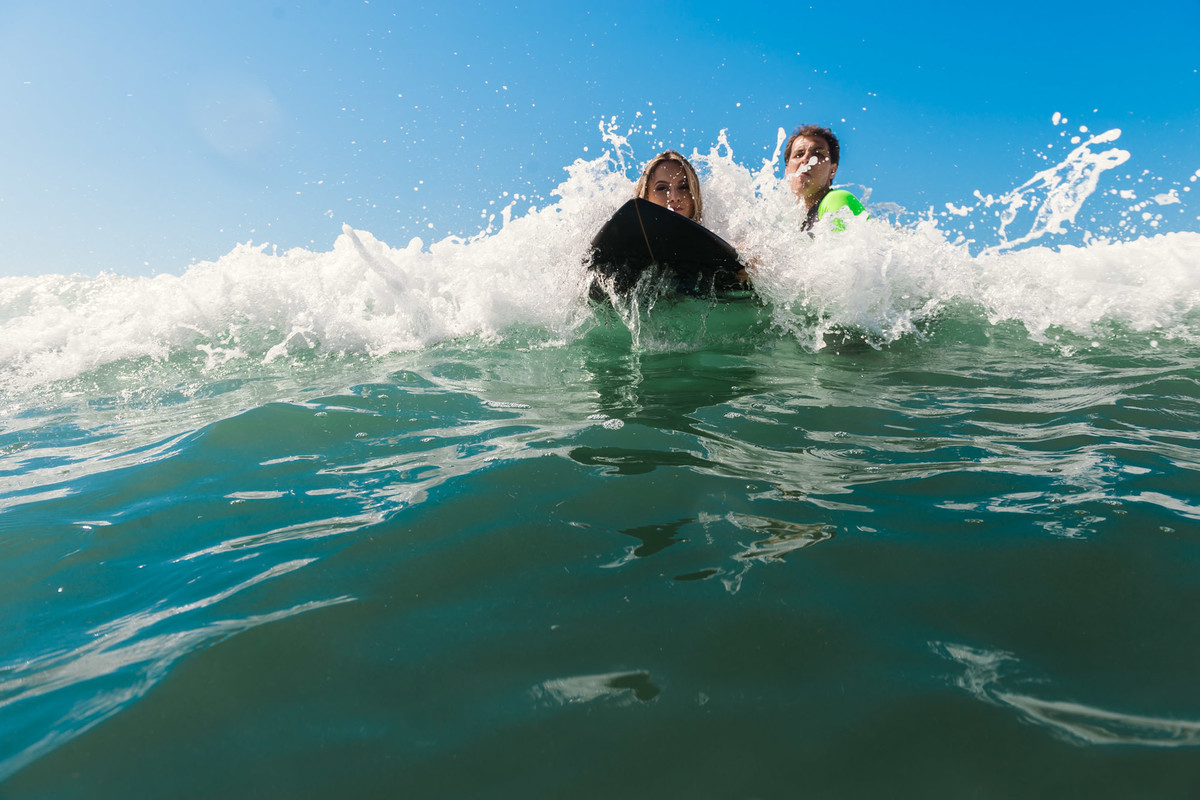 casal surfando juntos