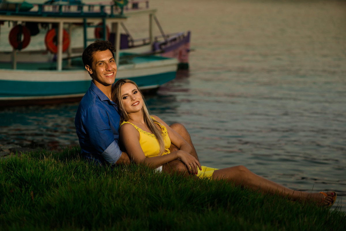 casal juntos com mar e barcos de fundo em Paraty