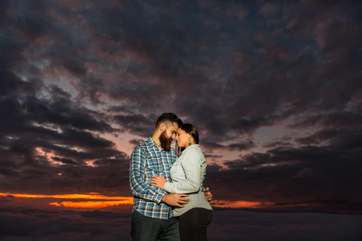 casal admirando o por do sol com mochila de viagem na Pedra do Baú em Campos do Jordão