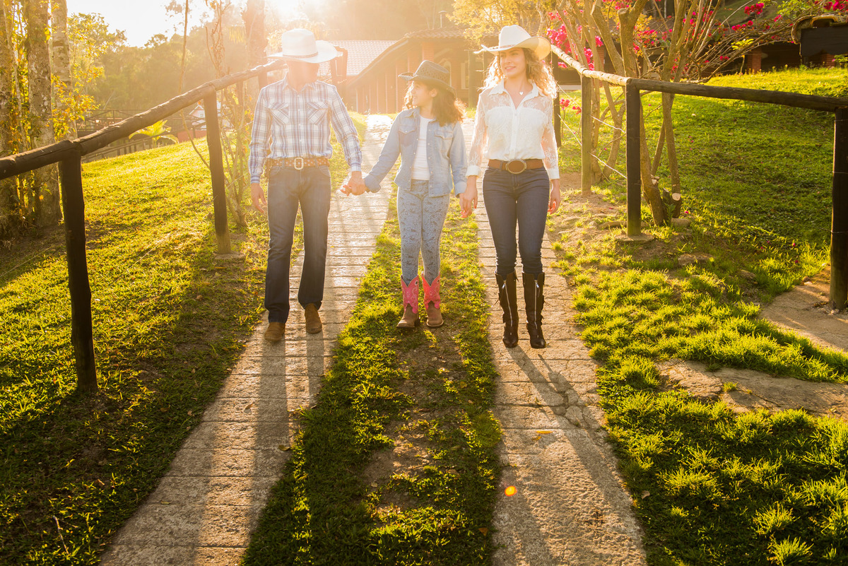 família caminhando com a luz do por do sol em sitio na cidade de Juquitiba