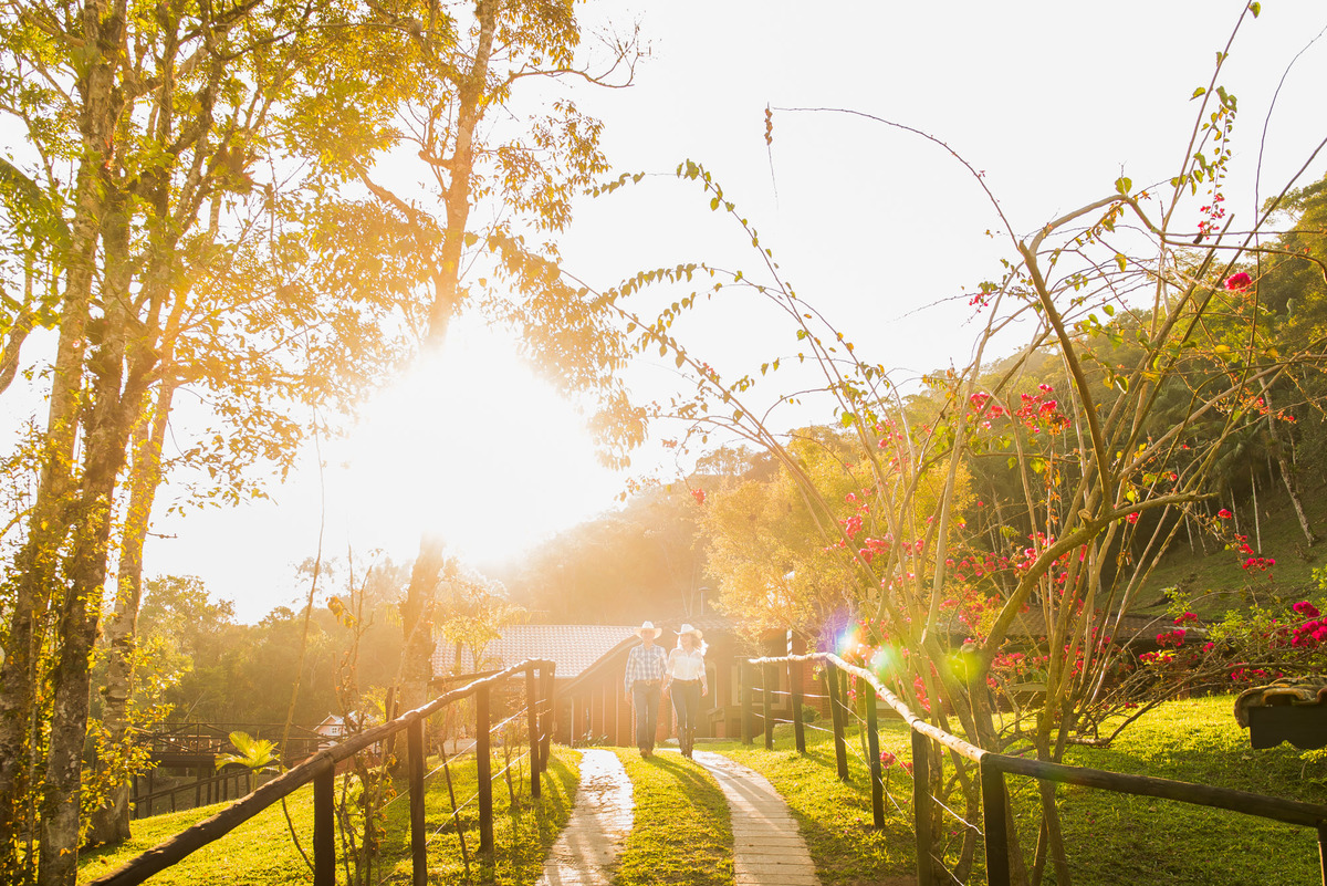 casal caminhando com a luz do por do sol em sitio na cidade de Juquitiba