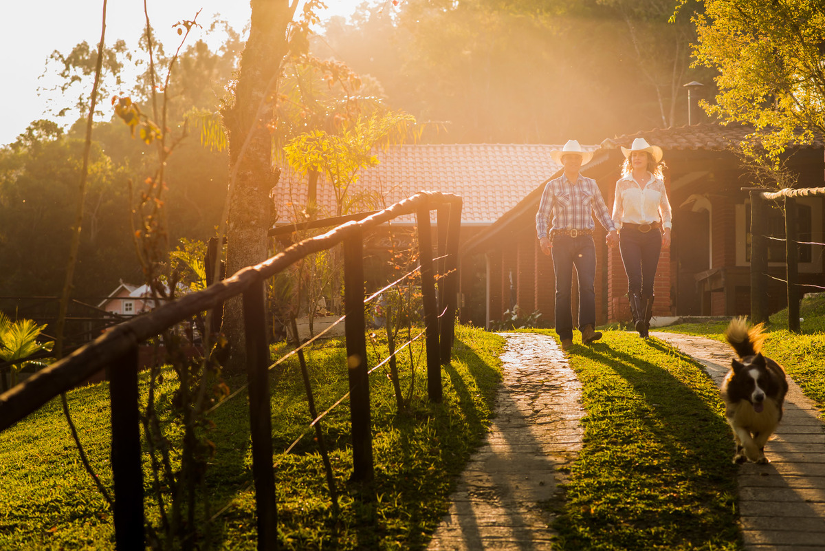 casal caminhando com a luz do por do sol em sitio na cidade de Juquitiba