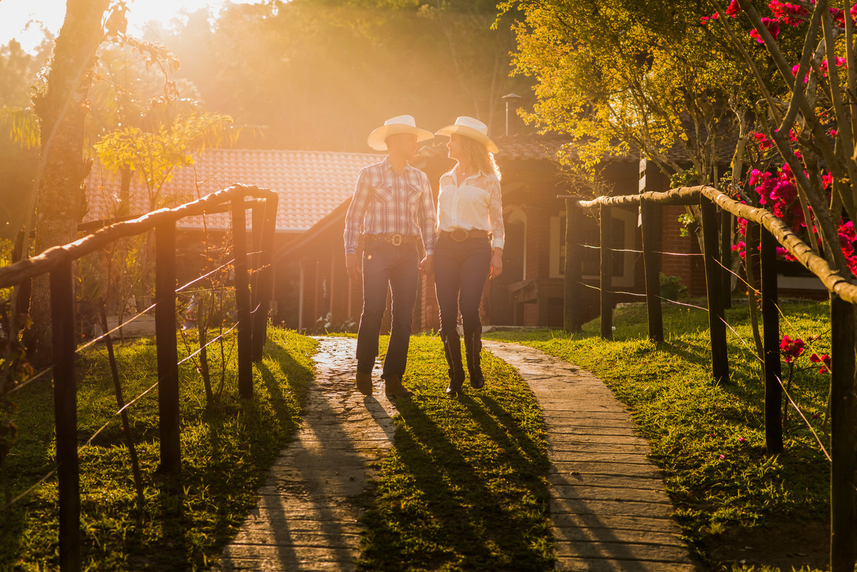 casal caminhando com a luz do por do sol em sitio na cidade de Juquitiba