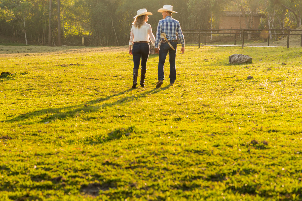 casal caminhando com a luz do por do sol em sitio na cidade de Juquitiba