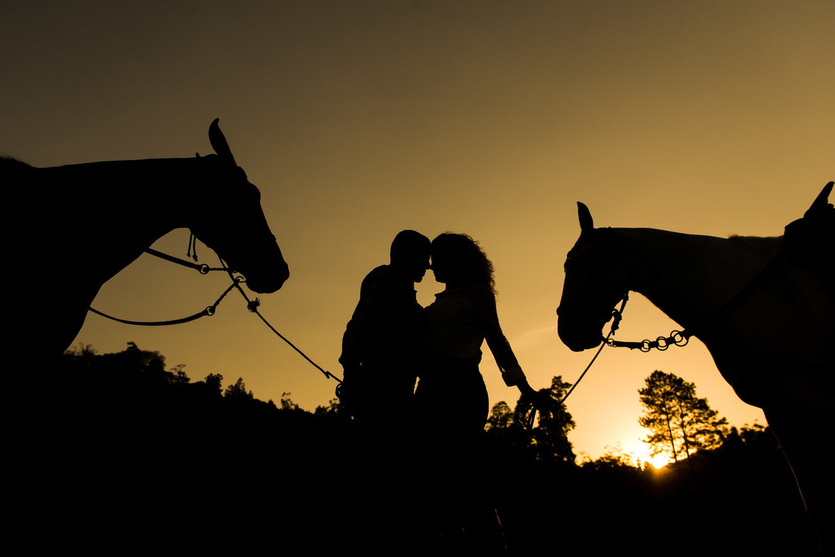 casal se beijando com a luz do por do sol em sitio na cidade de Juquitiba