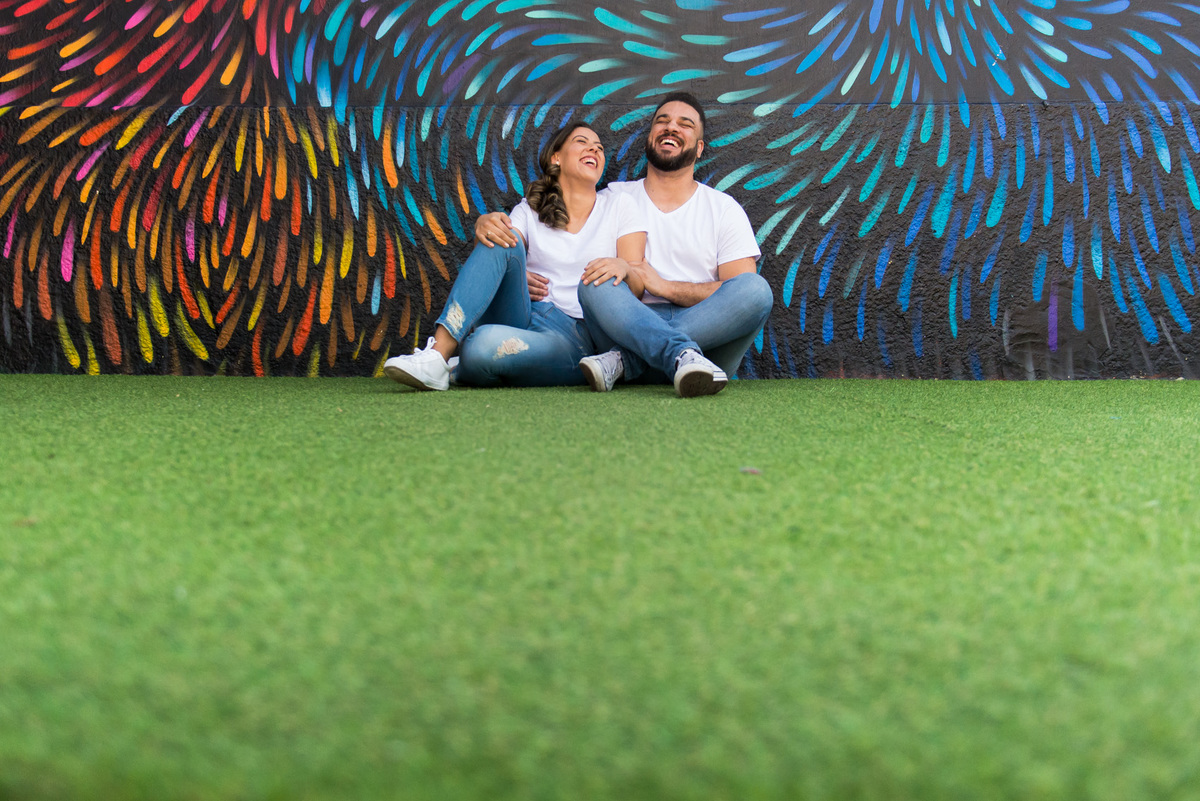 ensaio de casal sentados em grama sintetica no Beco do Batman na Vila Madalena