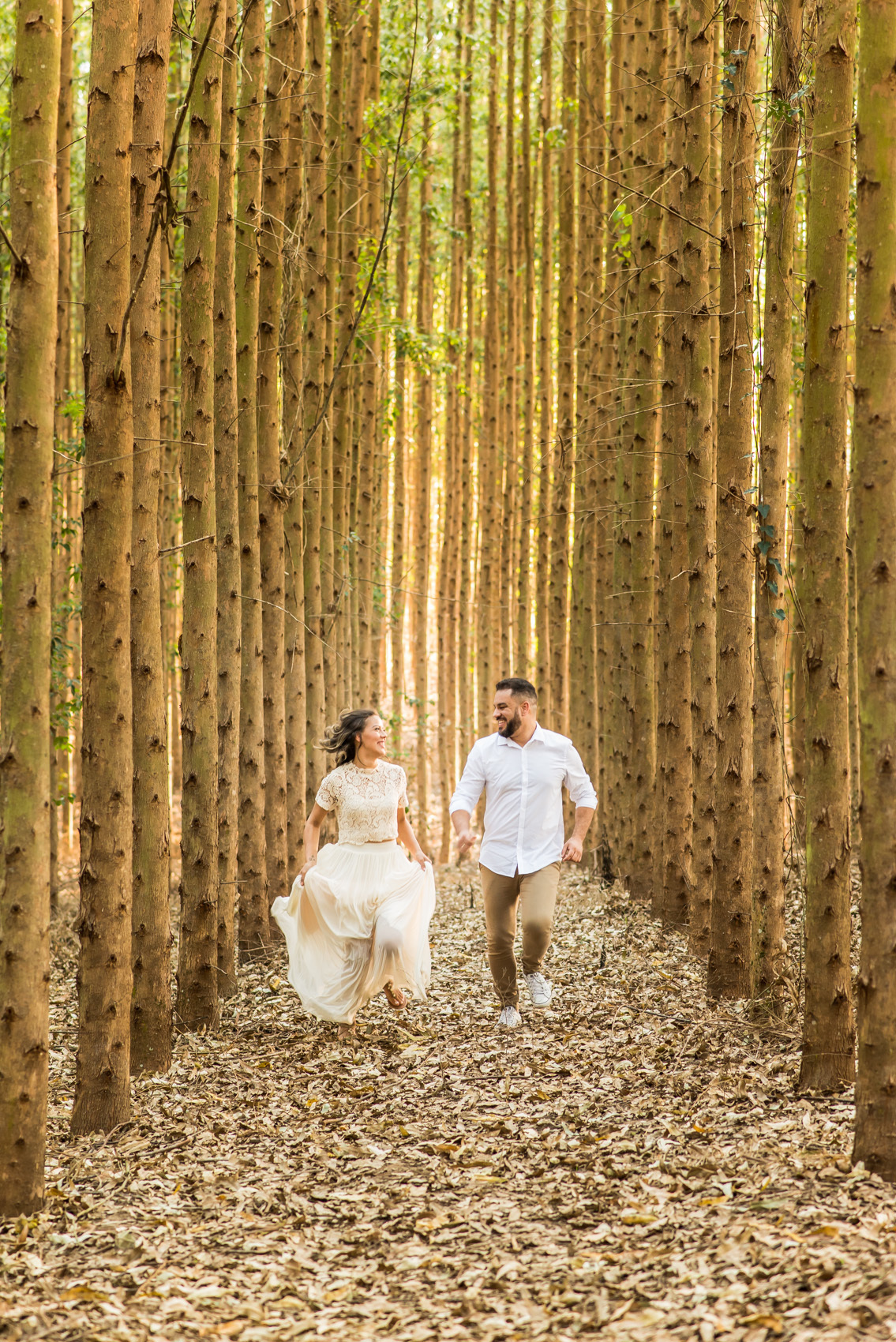 ensaio de casal, pre-wedding casal correndo em platação de eucaliptos em Holambra cidade das flores