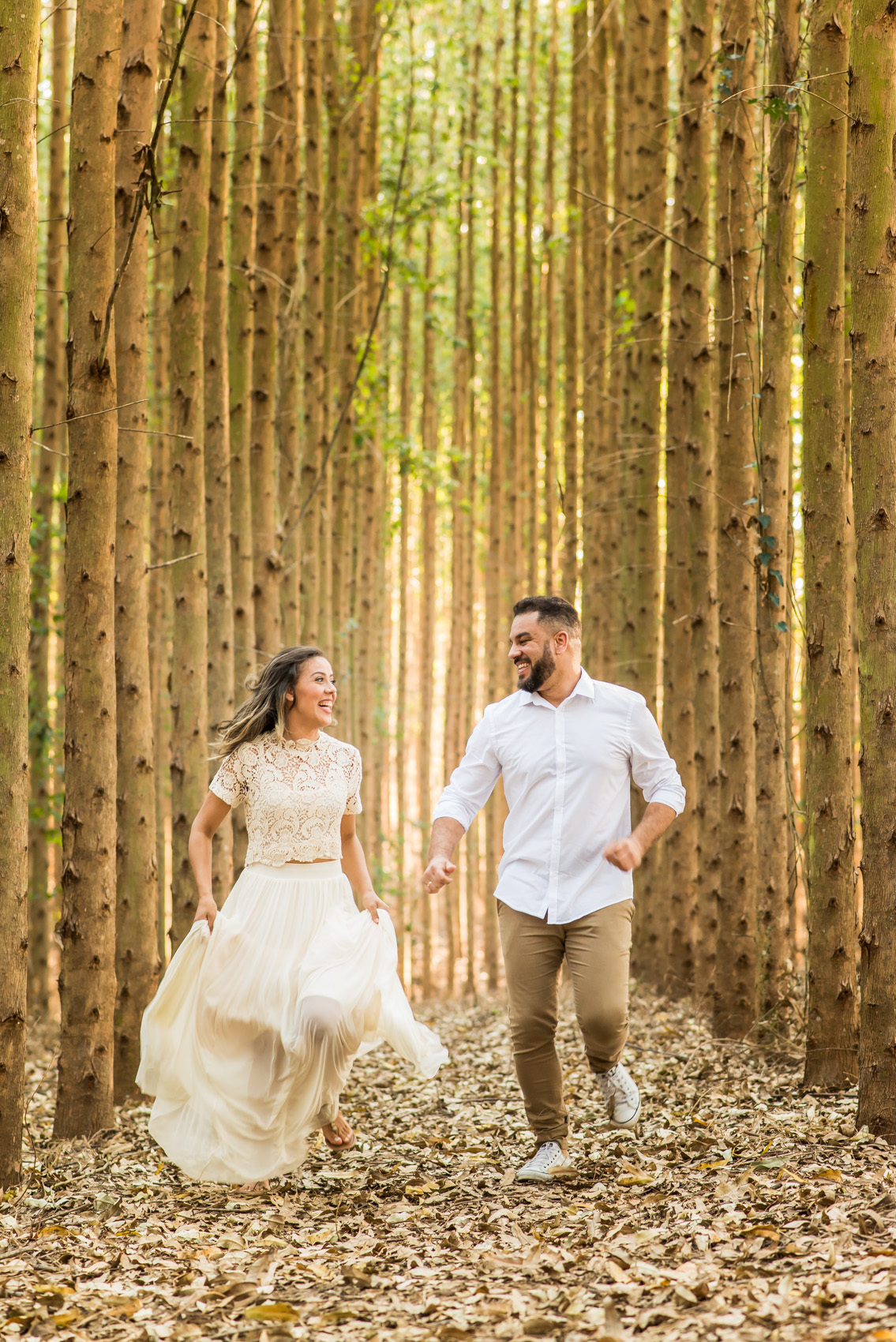 ensaio de casal, pre-wedding casal correndo em platação de eucaliptos em Holambra cidade das flores