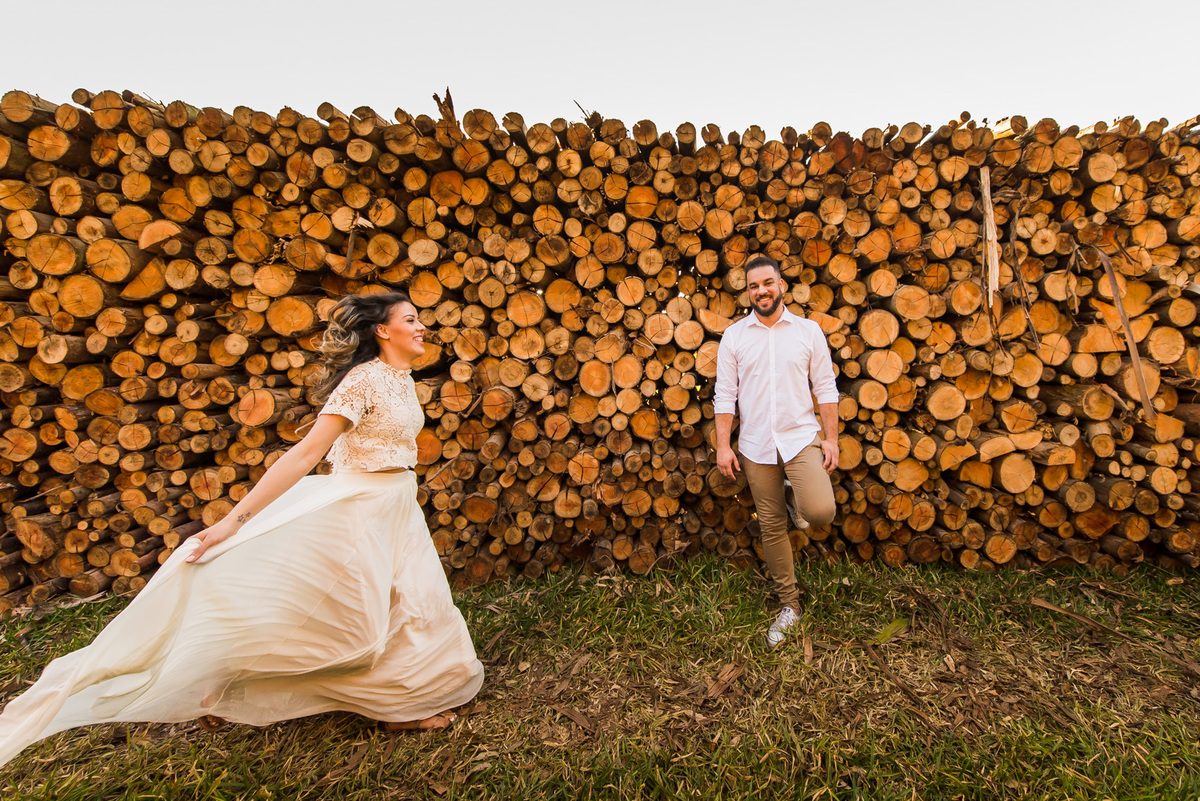 ensaio de casal, pre-wedding noiva correndo e noivo olhando em platação de eucaliptos em Holambra cidade das flores