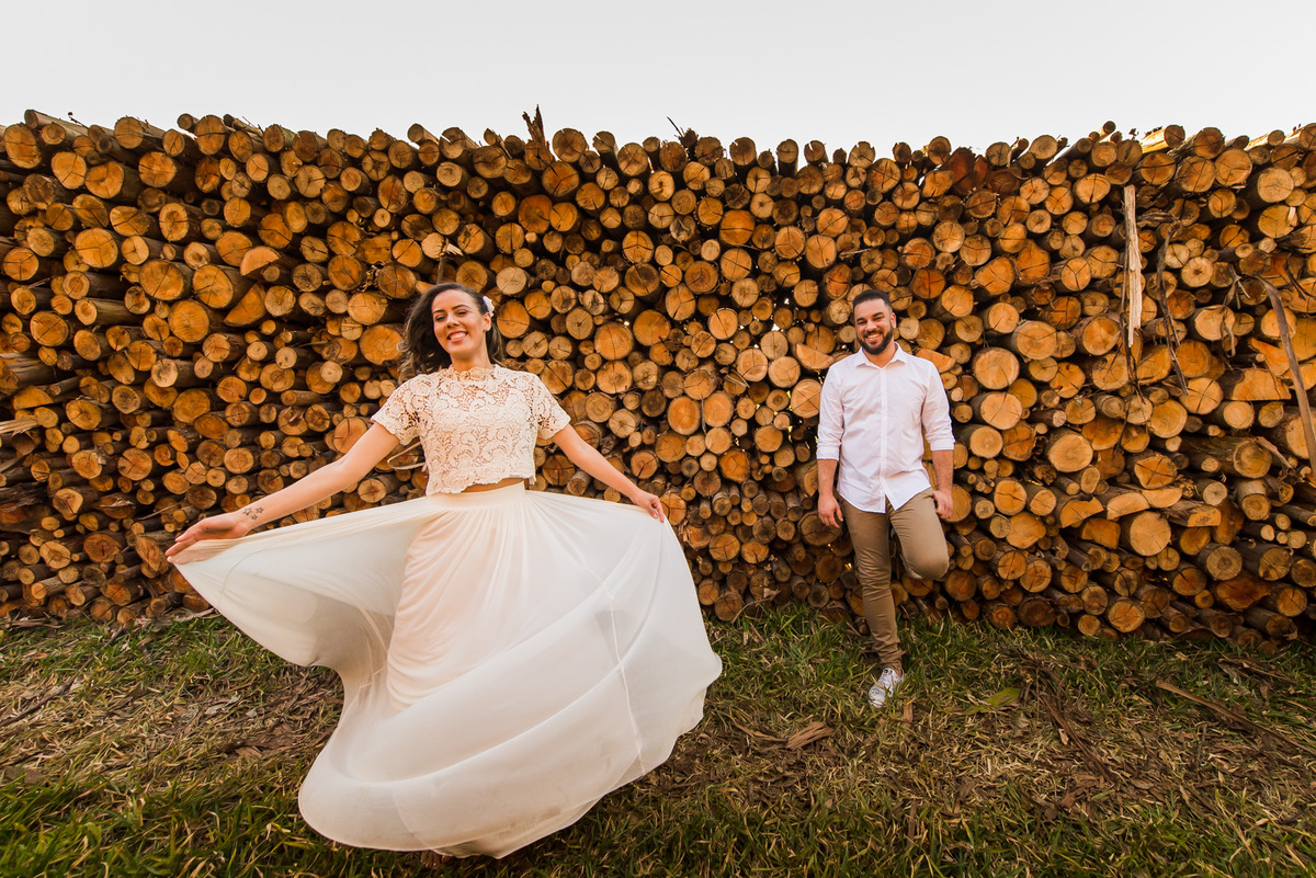 ensaio de casal, pre-wedding noiva girando e noivo olhando em platação de eucaliptos em Holambra cidade das flores