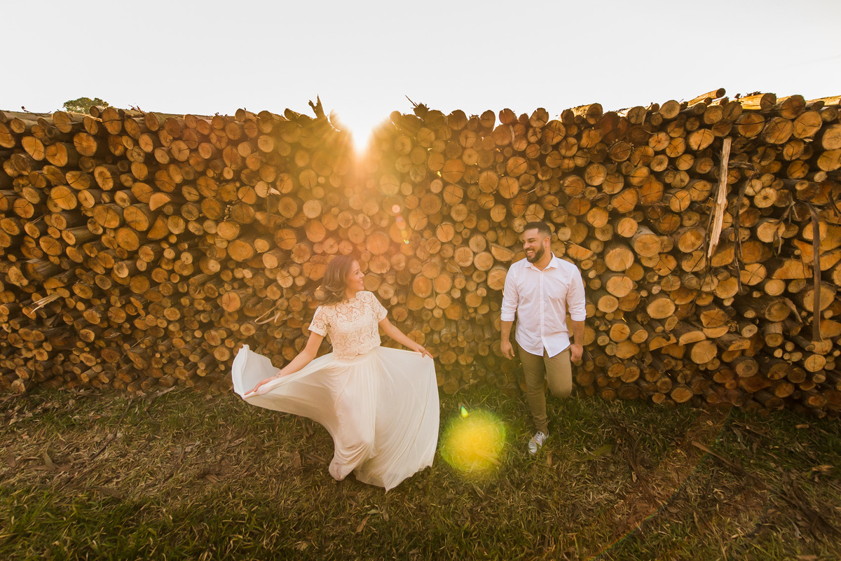 ensaio de casal, pre-wedding noiva girando e noivo olhando em platação de eucaliptos em Holambra cidade das flores