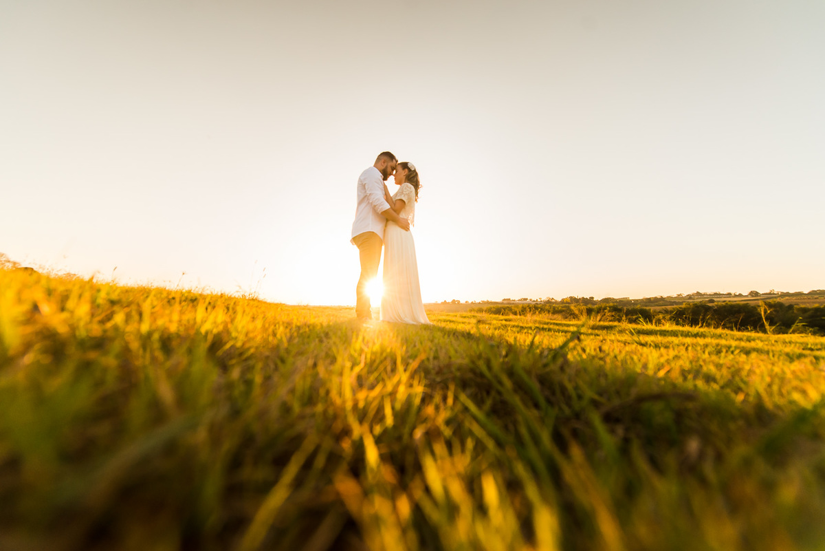 ensaio de casal, pre-wedding casal em campo de feno no por do sol em Holambra cidade das flores