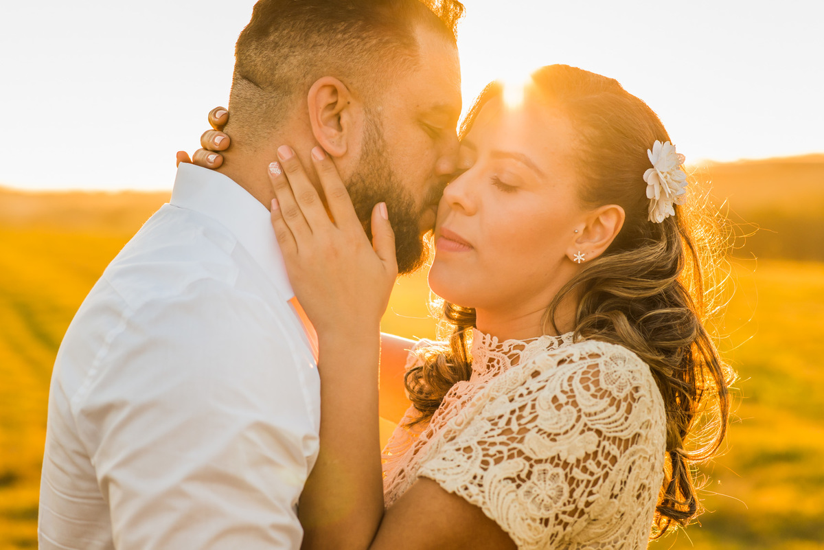 ensaio de casal, pre-wedding casal se beijando em campo de feno no por do sol em Holambra cidade das flores