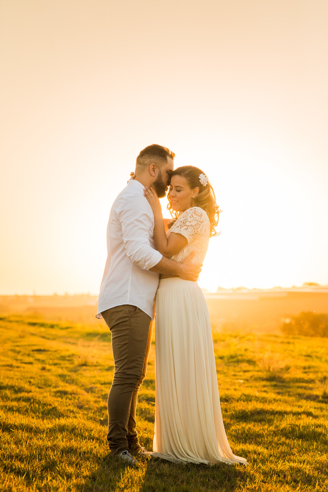 ensaio de casal, pre-wedding casal se beijando em campo de feno no por do sol em Holambra cidade das flores