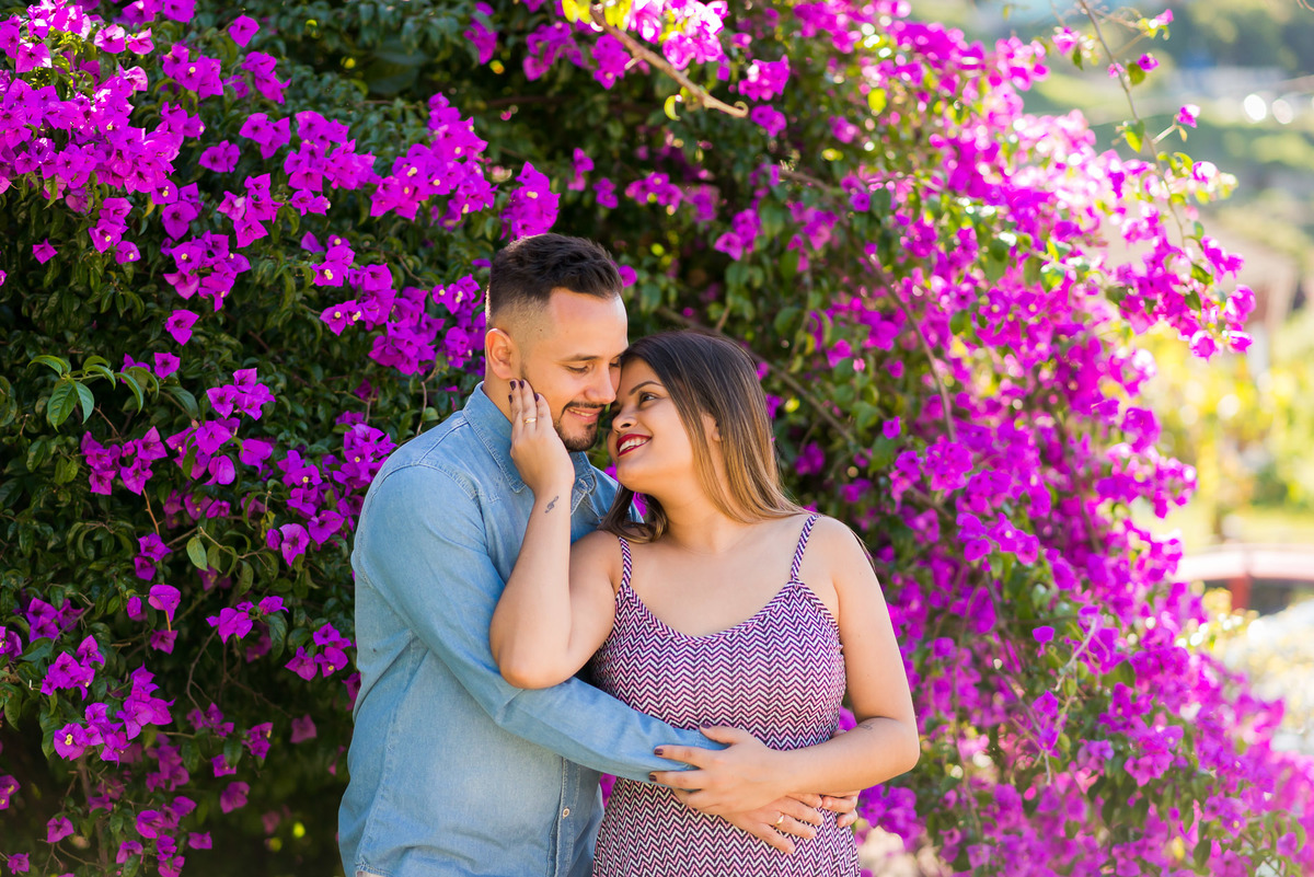 casal abraçados na cidade de Paranapiacaba com flores ao fundo