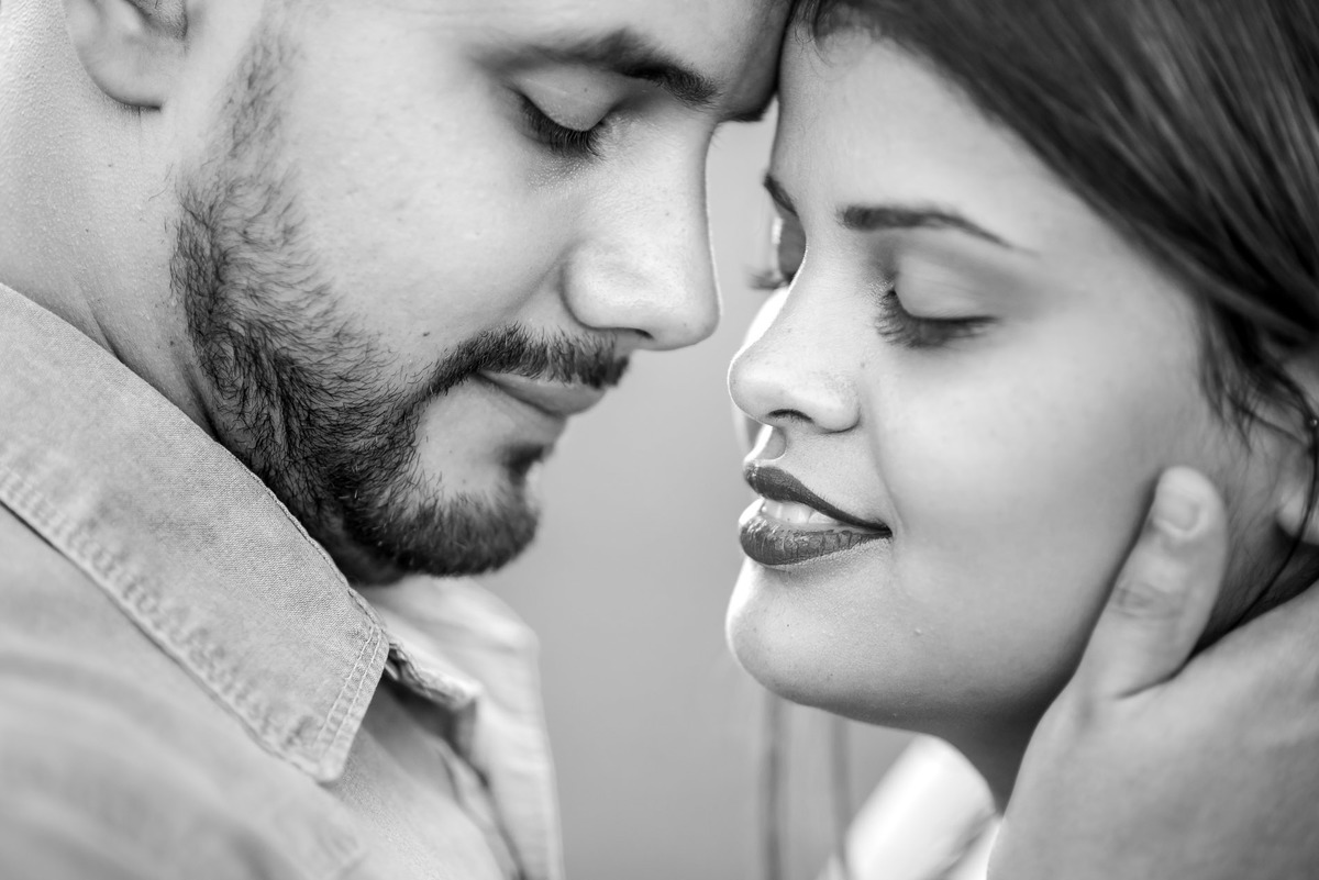 casal abraçados na passarela metalica na cidade de Paranapiacaba com arquitetura local ao fundo