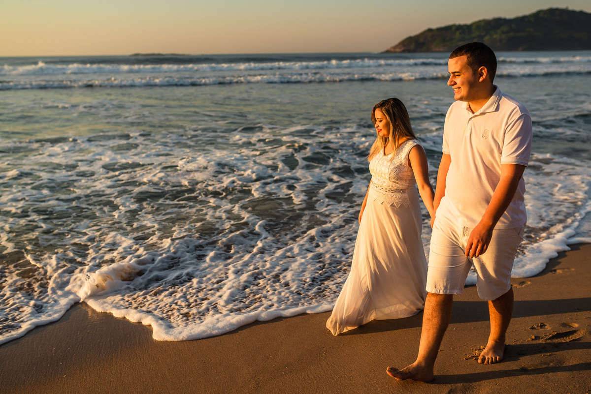 casal caminhando na praia do pernambuco guaruja nascer do sol