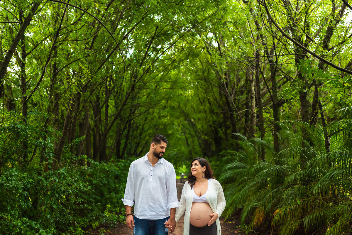 casal gestante de mãos dadas se olhando em caminho de terra em Holambra - cidade das flores