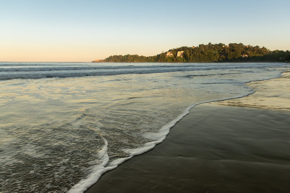 onda do mar na praia do Iporanga no Guarujá com por do sol ao fundo