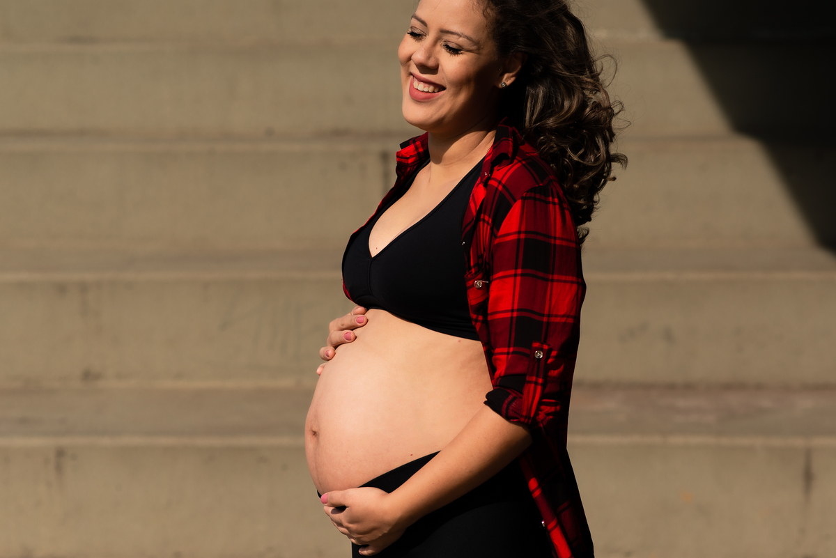 ensaio de gestante com mulher fazendo carinho na barriga no parque villa lobos em São Paulo