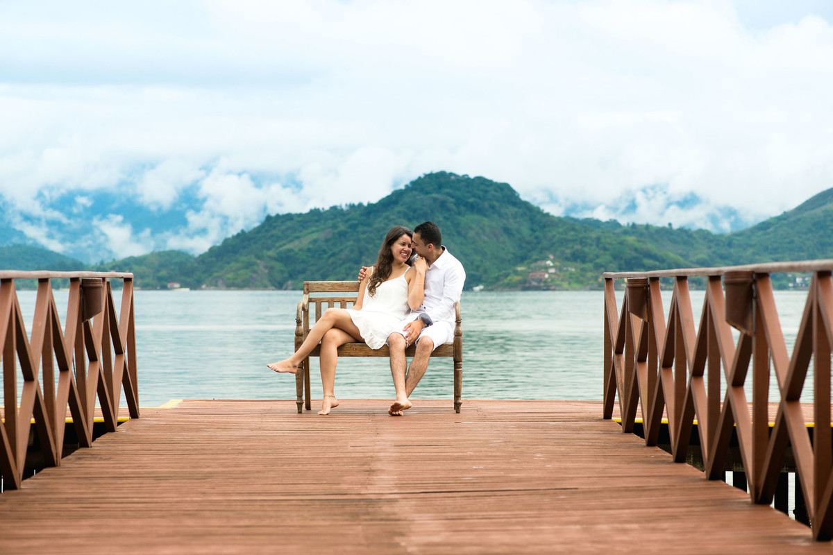 casal sentado em banco na praia de angra dos reis