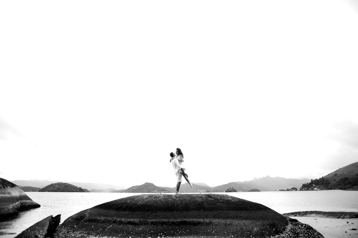 casal em cima de pedra na praia de angra dos reis