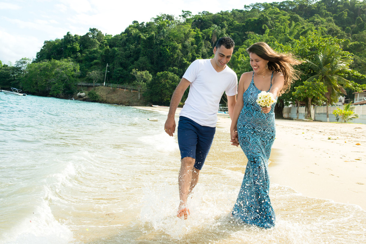 casal correndo com pé na agua na praia em angra dos reis