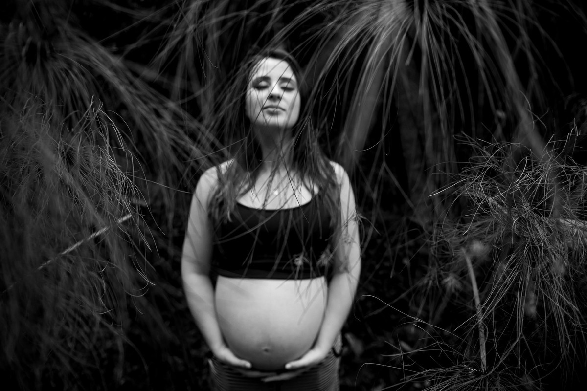 mulher gestante em pé no jardim botânico em são paulo