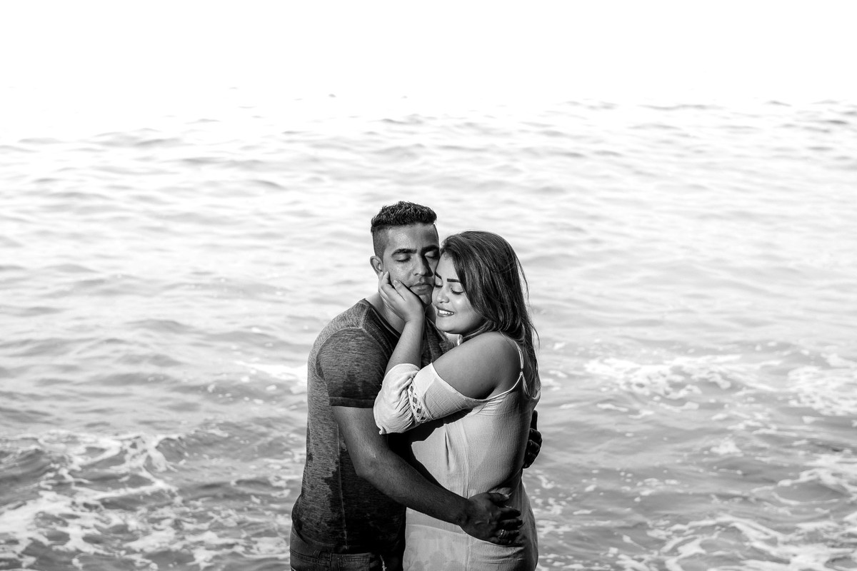 casal abraçados em cima de rochas ao lado do marna praia do Eden no Guaruja em São Paulo