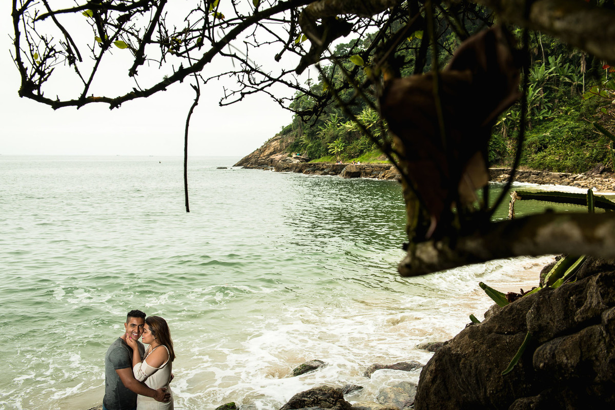casal abraçados em cima de rochas ao lado do marna praia do Eden no Guaruja em São Paulo