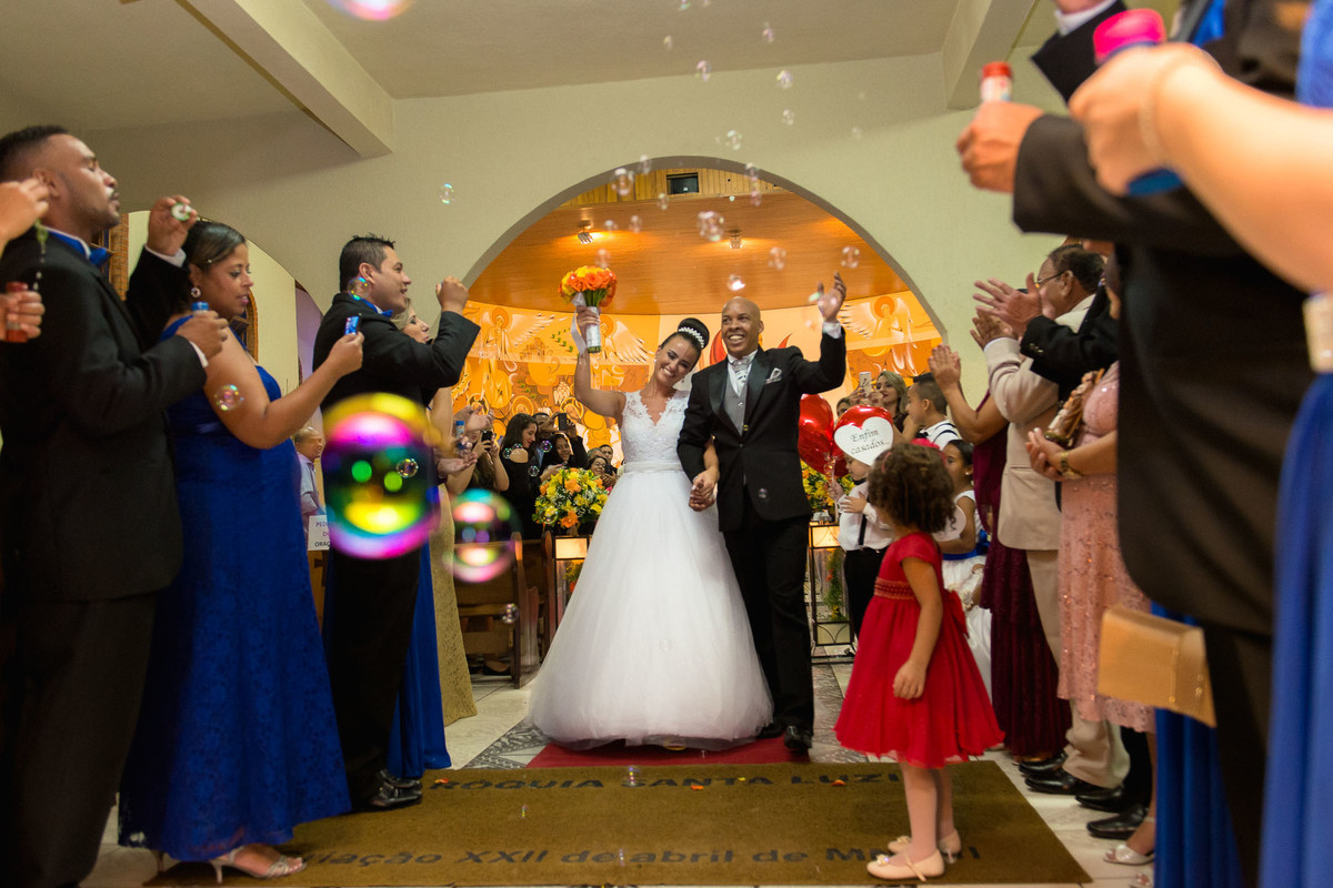 noivos comemoram na saida da igreja e padrinhos jogam bolhas de sabão no casal na igreja Paroquia Santa Luzia em São Paulo