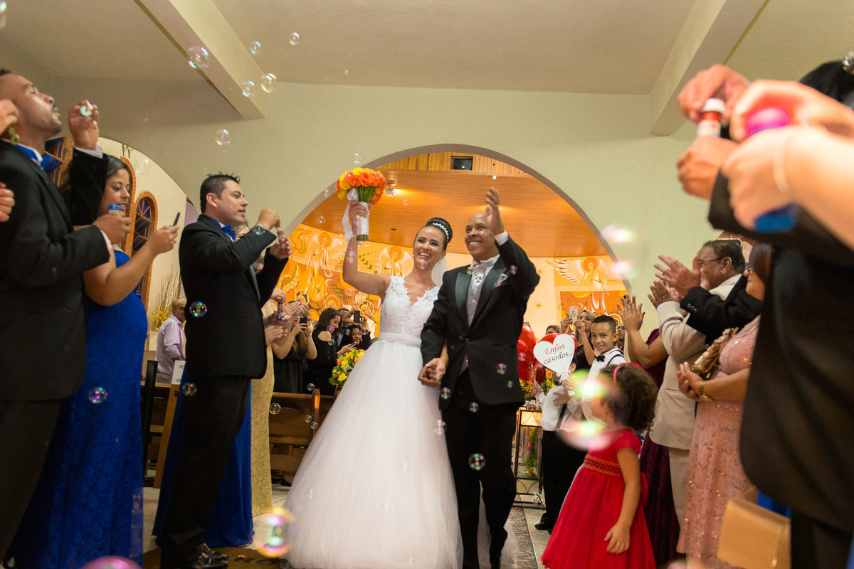 noivos comemoram na saida da igreja e padrinhos jogam bolhas de sabão no casal na igreja Paroquia Santa Luzia em São Paulo
