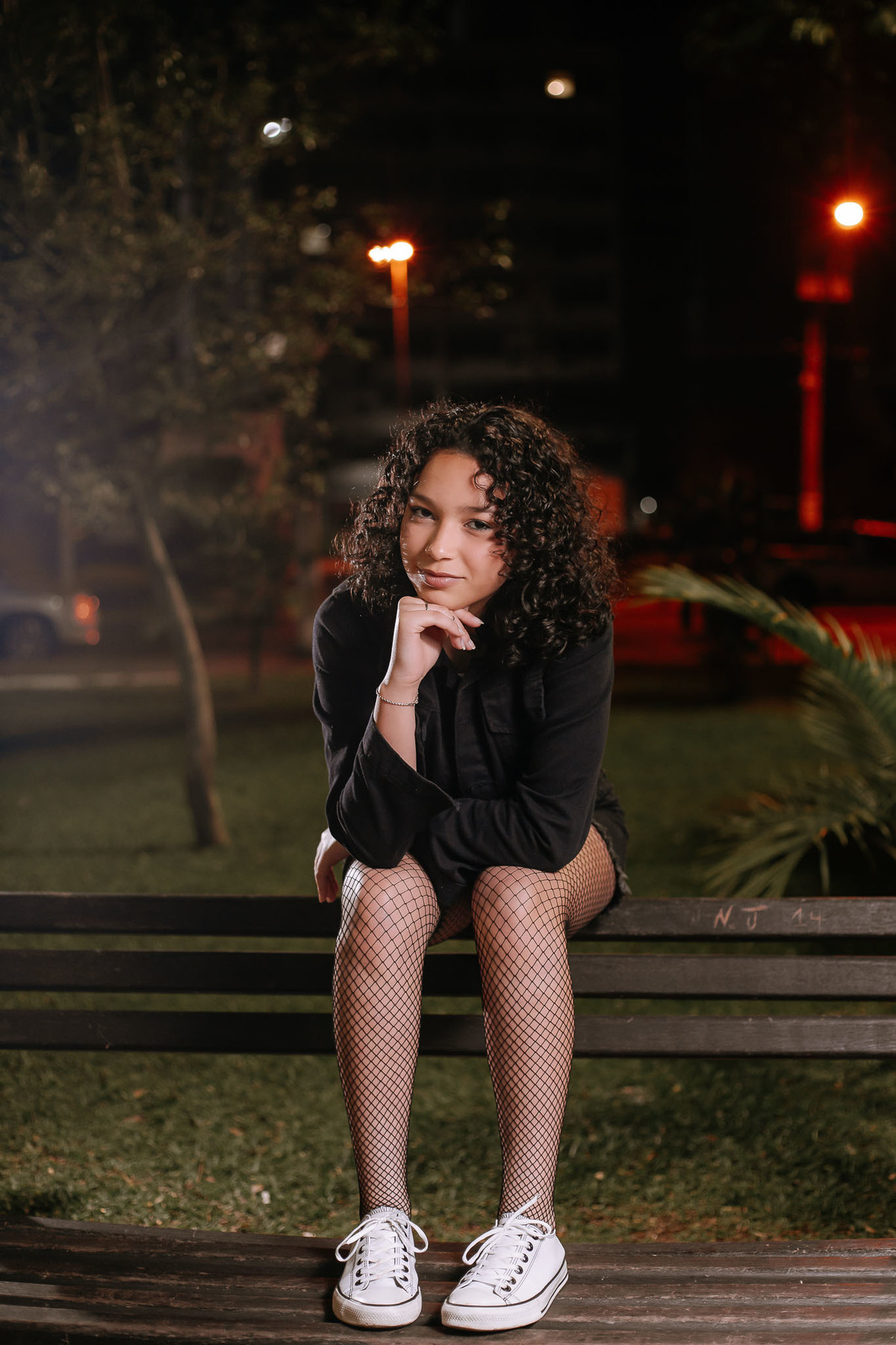 Ensaio de 15 anos em Canoas com estilo urbano noturno, debutante em frente a avião com iluminação dramática