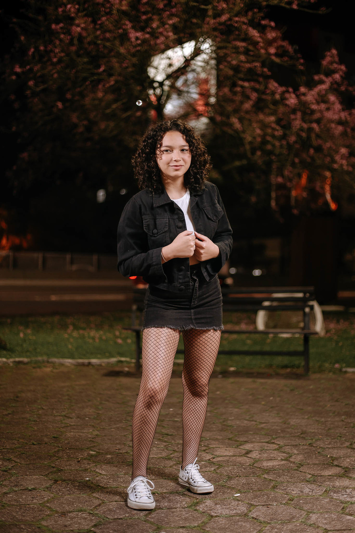 Ensaio de 15 anos em Canoas com estilo urbano noturno, debutante em frente a avião com iluminação dramática