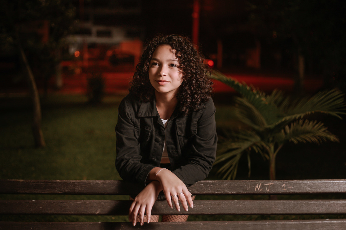 Ensaio de 15 anos em Canoas com estilo urbano noturno, debutante em frente a avião com iluminação dramática