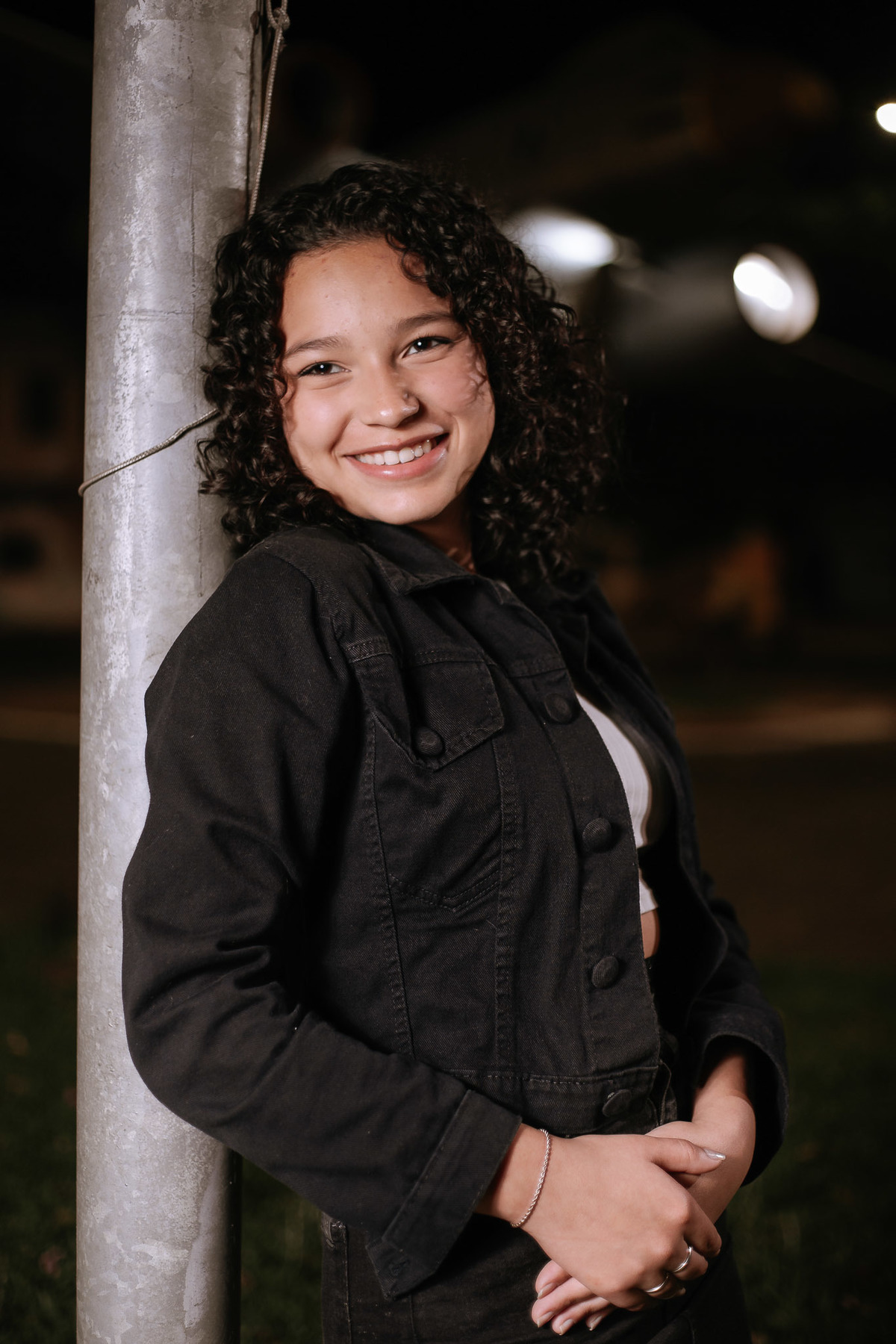 Ensaio de 15 anos em Canoas com estilo urbano noturno, debutante em frente a avião com iluminação dramática