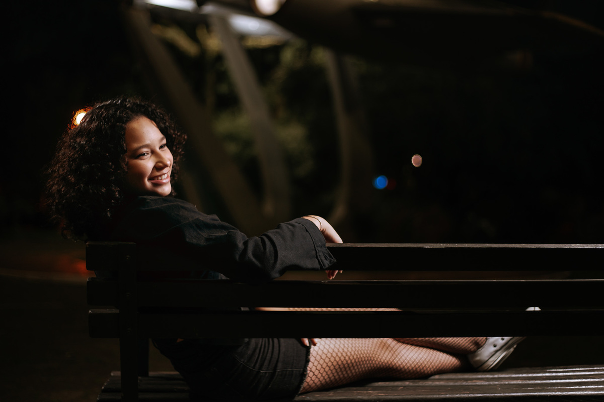 Ensaio de 15 anos em Canoas com estilo urbano noturno, debutante em frente a avião com iluminação dramática