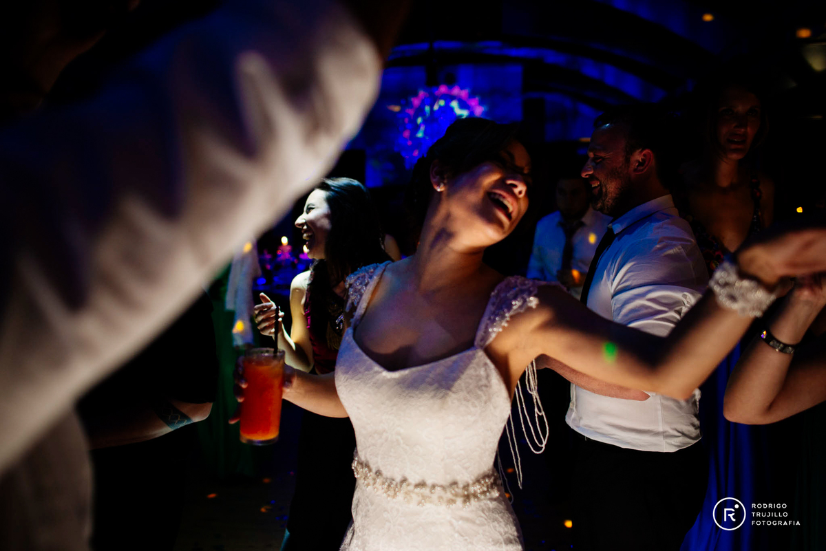 fiestas divertidas de bodas, fotografia a color, fotos de la novia en la fiesta, novia bailando con copa en la mano, luces de colores del salon terrazas del parana en rosario, santa fe. fotograia de bodas en rosario